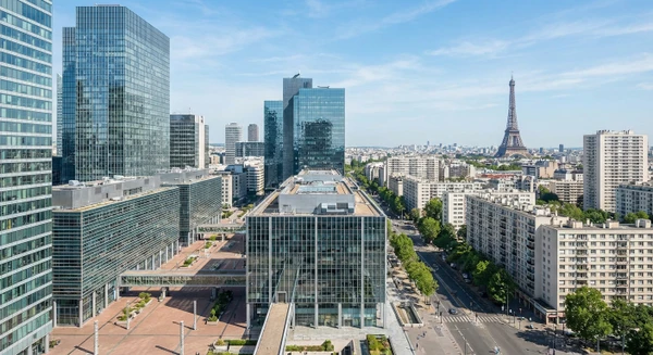 Vue a&eacute;rienne ou urbaine de Paris montrant l'architecture moderne et les b&acirc;timents de bureaux du quartier d'affaires, ou une rue parisienne typique avec immeubles haussmanniens, illustrant le contexte g&eacute;ographique professionnel o&ugrave; intervient l'entreprise de nettoyage. L'image doit &ecirc;tre claire et reconnaissable comme &eacute;tant Paris, en mettant l'accent sur l'environnement urbain et professionnel.