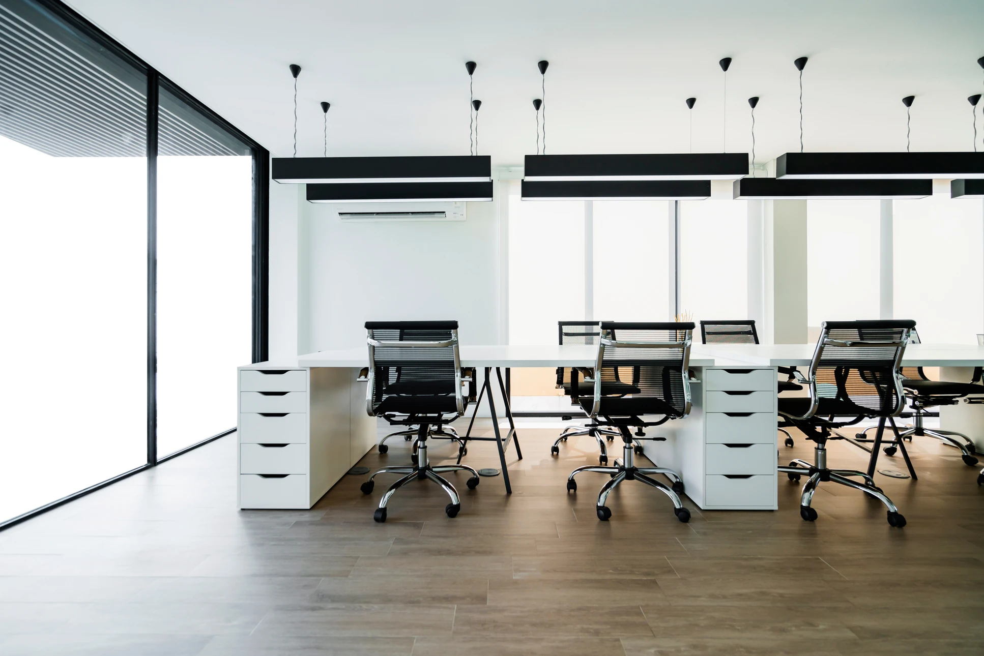 Espace de bureau moderne en open space avec plusieurs postes de travail équipés d'ordinateurs et moniteurs